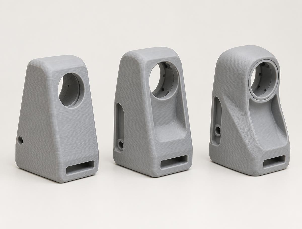 Three grey 3D printed prototype housings showing design revisions